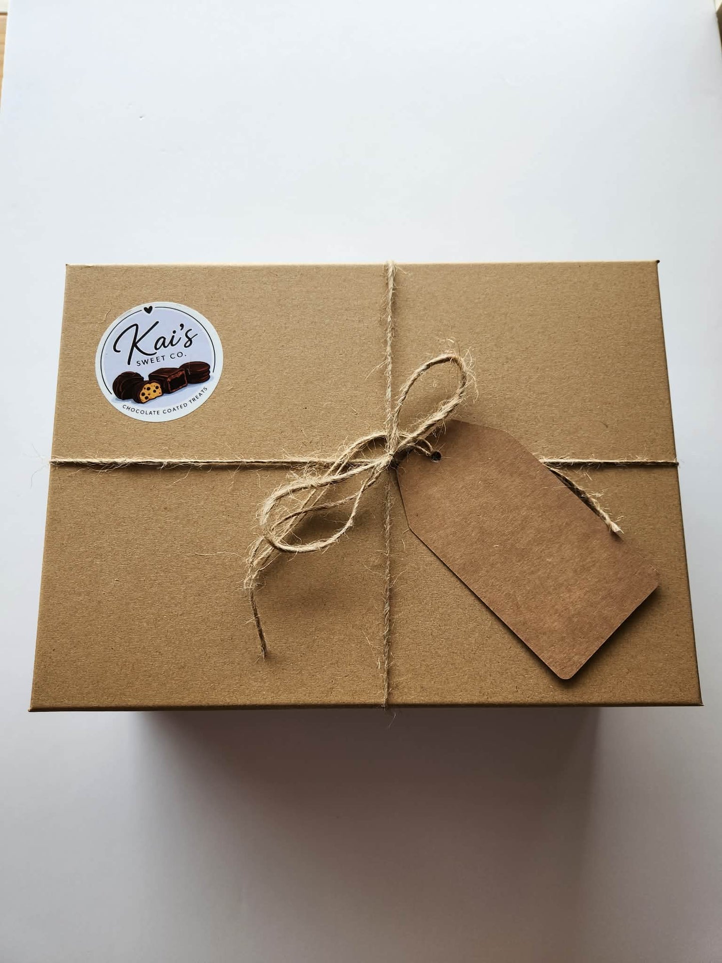 Kai's Sweet Co Large Gift Box closed with kraft box, twine tie and Kai's Sweet Co logo gift tag ready to gift