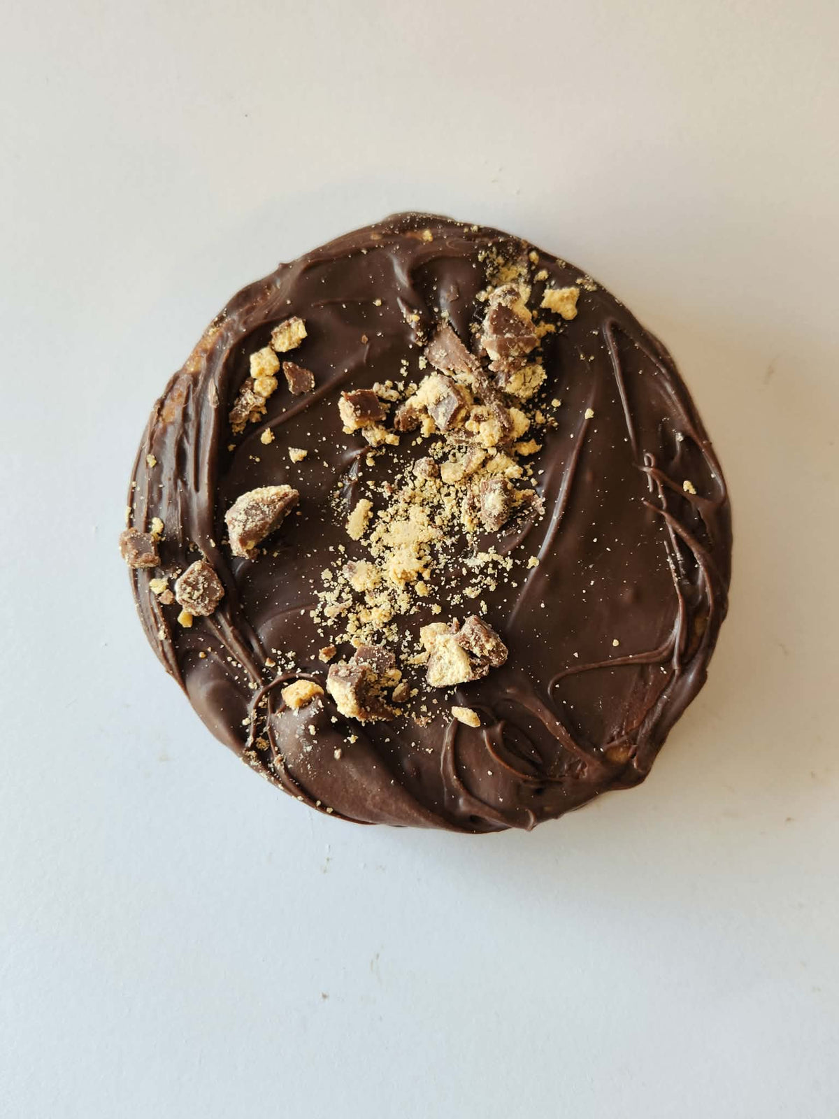 Kai's Sweet Co Peanut Butter Roundabout top down view, milk chocolate coated with peanut butter crumble and chunk topping