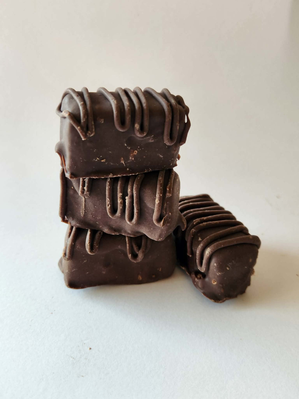 Kai's Sweet Co Mini Chocolate Brownie Bars stacked four high with chocolate drizzle, handmade chocolate coated treats