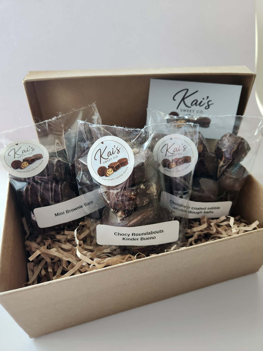 Kai's Sweet Co Father's Day Gift Box open showing mini brownie bars, Kinder Bueno roundabouts and chocolate coated cookie dough balls nestled in shredded paper