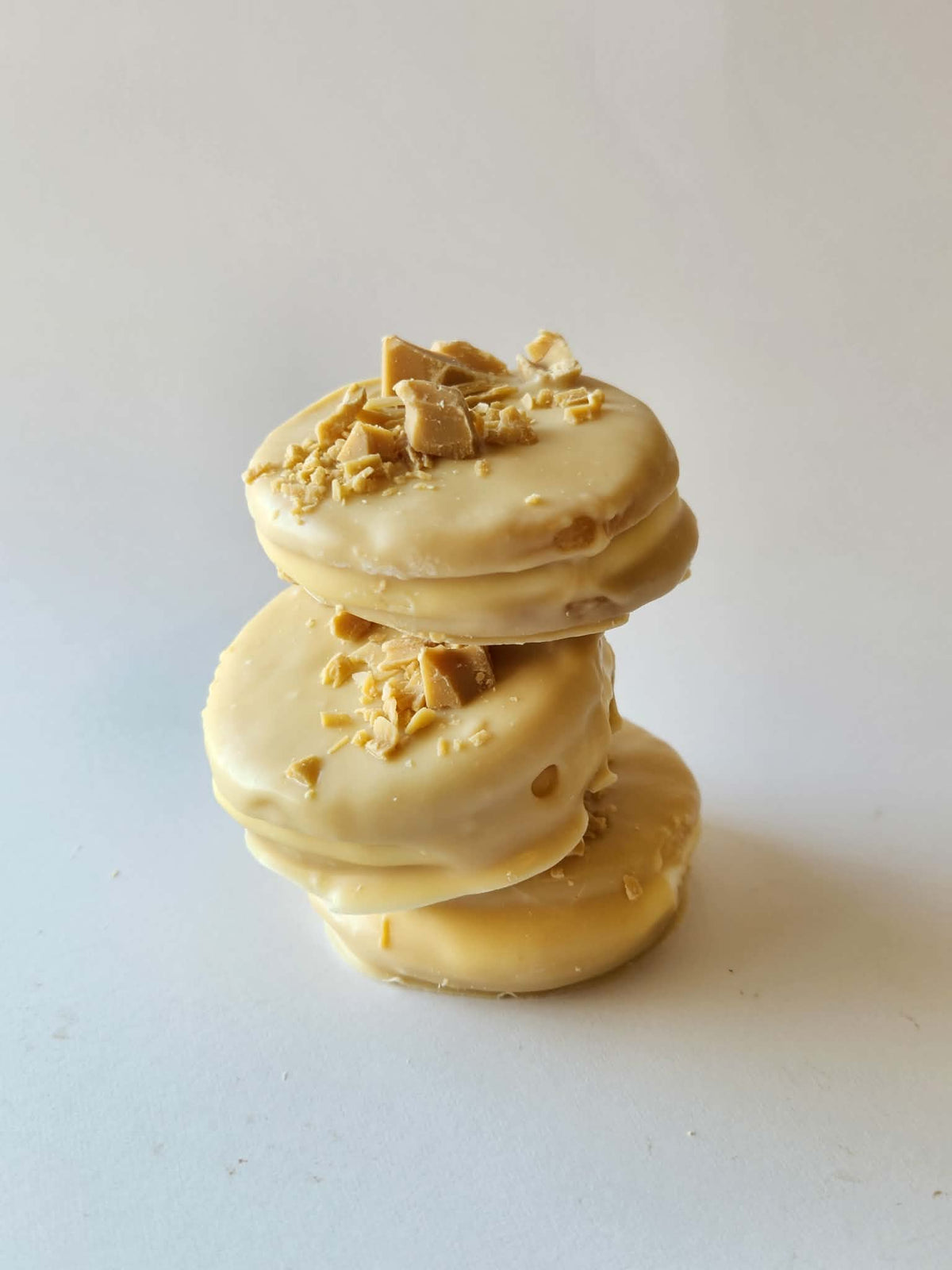 Kai's Sweet Co Caramilk Mini Roundabouts stacked three high, white chocolate coated with Caramilk crumble topping