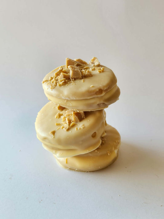 Kai's Sweet Co Caramilk Mini Roundabouts stacked three high, white chocolate coated with Caramilk crumble topping