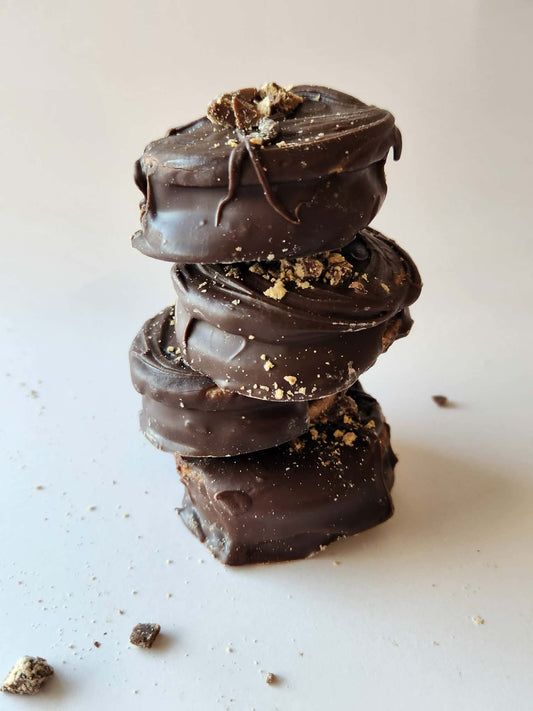 Kai's Sweet Co Peanut Butter Mini Roundabouts stacked four high with peanut butter crumble topping, chocolate coated handmade treats