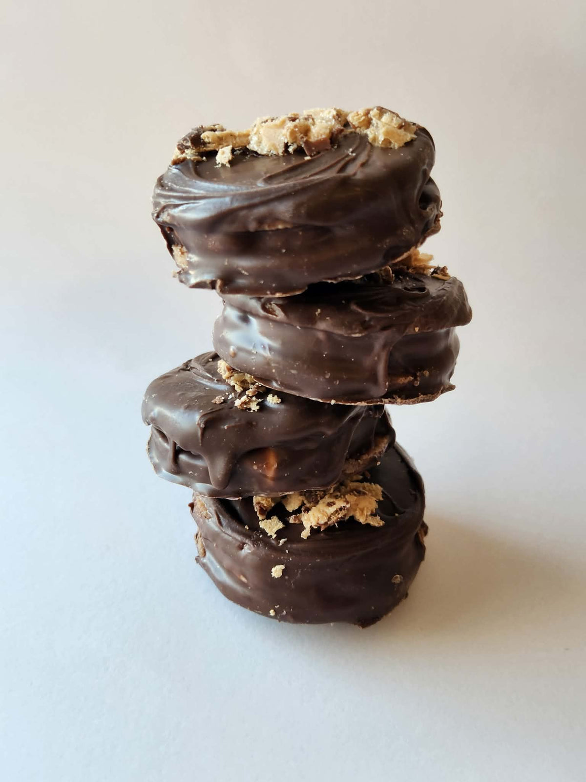 Kai's Sweet Co Kinder Bueno Mini Roundabouts stacked four high with Kinder Bueno wafer crumble topping, dark chocolate coated