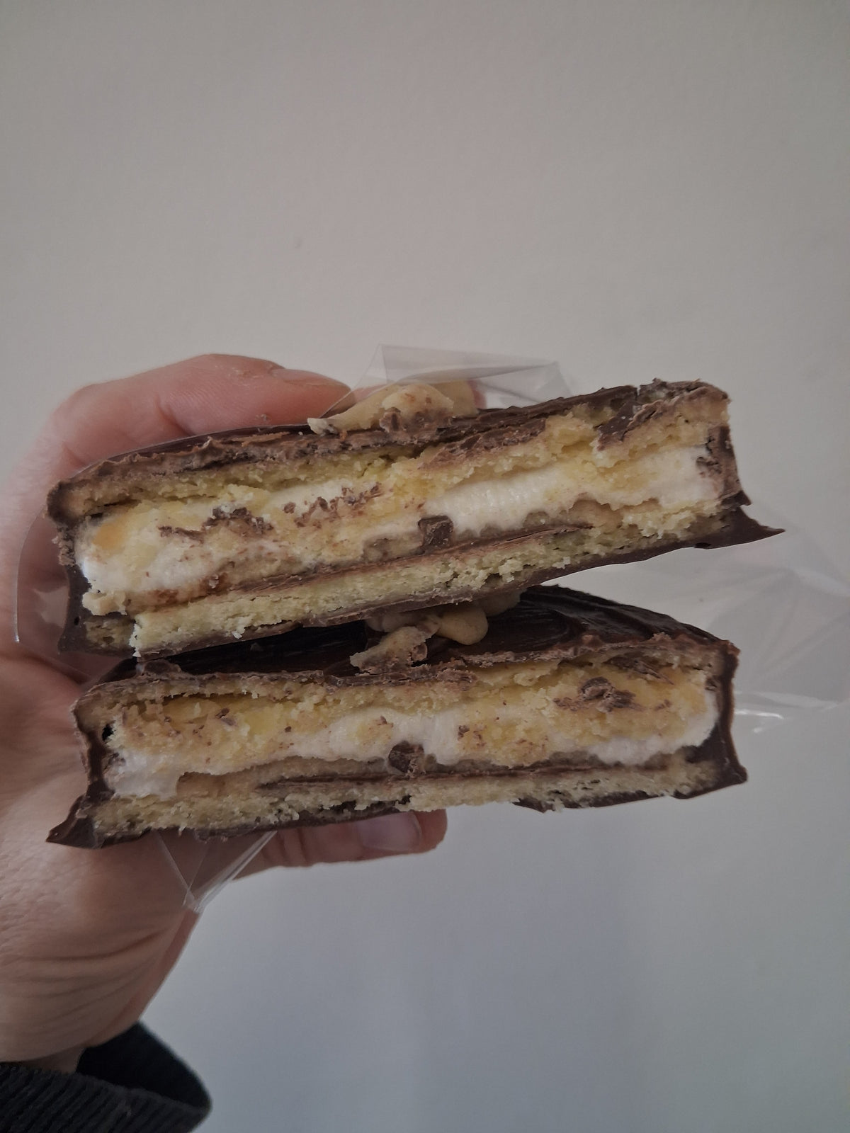 Kai's Sweet Co Cookie Dough Roundabout cut in half showing layered cookie dough and chocolate filling

