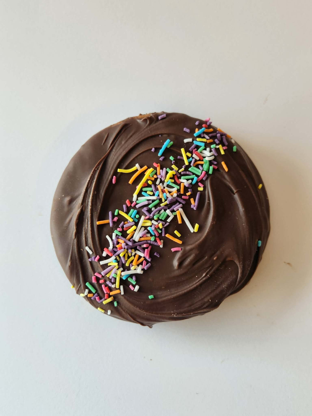 Kai's Sweet Co The Angelique Roundabout top down view, milk chocolate coated with rainbow sprinkles, handmade sweet treat